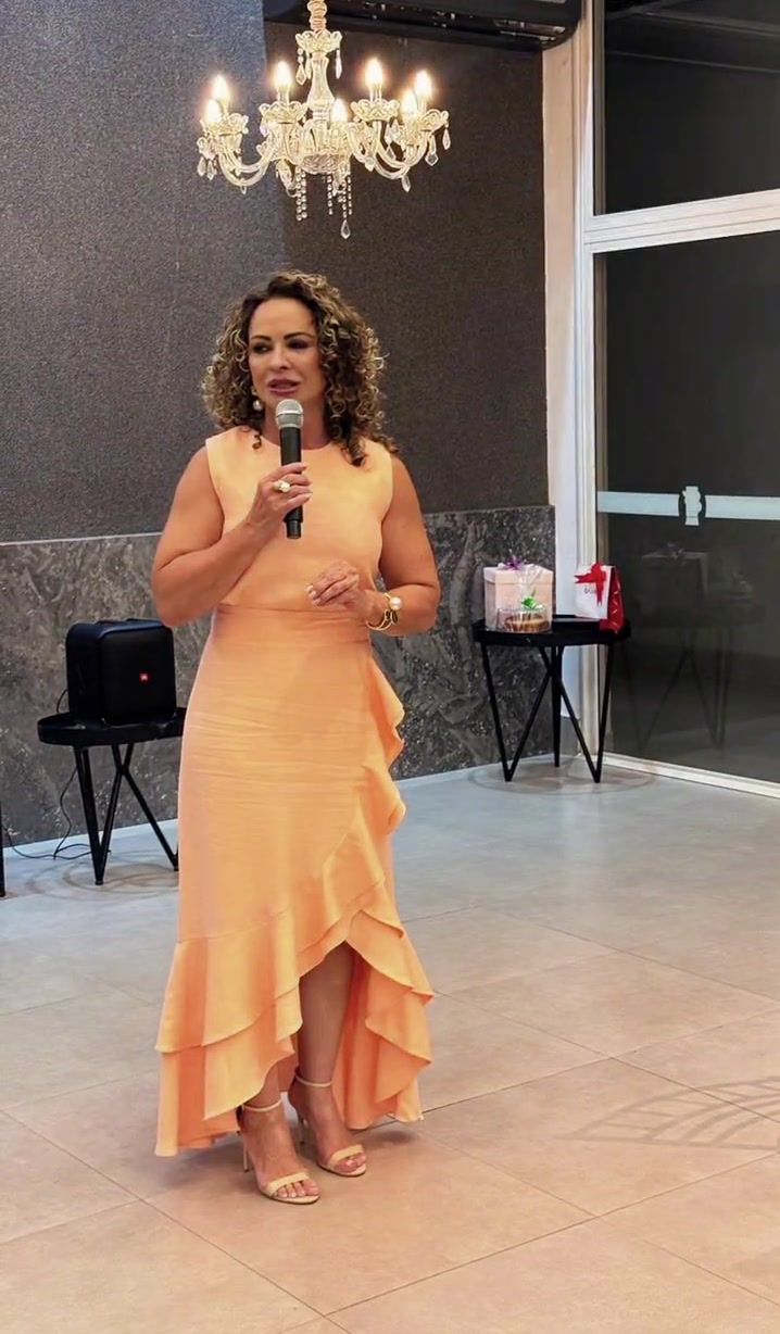 Sandra Mara Castro ministrando uma palestra com o microfone nas mãos